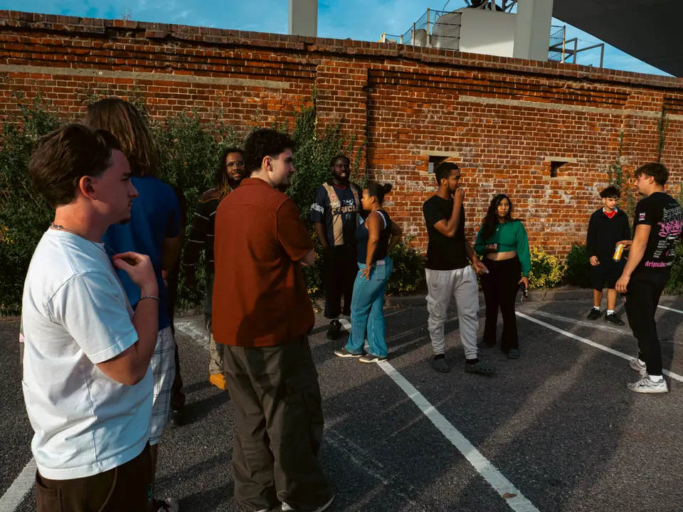 The crew gathered against a red brick wall in the late afternoon
